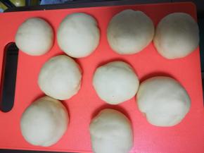 将发酵好的面团放案板排气完成后，平均分为9等份，滚圆静置15分钟。