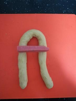 将它对折，放上火腿肠，