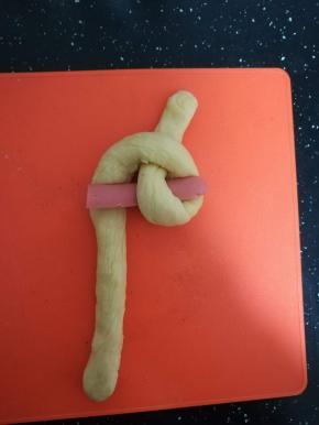 将下面一根面条从对折点的洞中穿过去。6