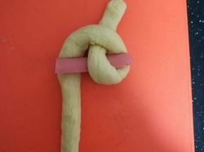 将下面一根面条从对折点的洞中穿过去。6