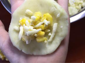 准备20克大小的土豆泥搓圆在压平将玉米粒芝士碎放中间