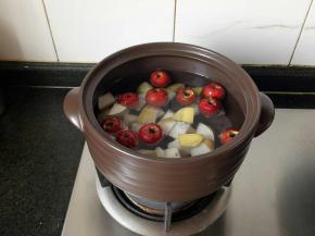 山楂和梨块一同放锅里煮。