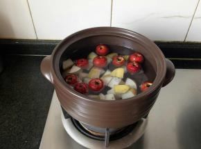 山楂和梨块一同放锅里煮。