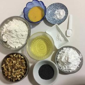 准备好所需食材: 
核桃仁120克，低筋面粉220克，玉米油100克，鸡蛋液40克，糖粉60克，小苏打2克，泡打粉2克，盐2克，黑芝麻10克，刷桃酥表面的蛋液5克(我这是美的32升烤箱，两盘同时烤，只做一盘的，把配方中的量减半就可以了！)