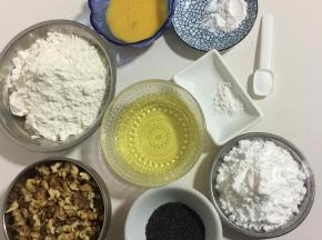 准备好所需食材: 
核桃仁120克，低筋面粉220克，玉米油100克，鸡蛋液40克，糖粉60克，小苏打2克，泡打粉2克，盐2克，黑芝麻10克，刷桃酥表面的蛋液5克(我这是美的32升烤箱，两盘同时烤，只做一盘的，把配方中的量减半就可以了！)