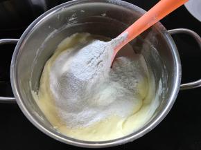 筛入一半的低粉和泡打粉，用刮刀翻拌均匀。