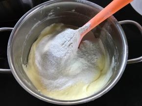 筛入一半的低粉和泡打粉，用刮刀翻拌均匀。