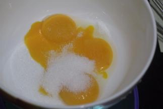 将蛋清和蛋黄分离后，在蛋黄盆子里加入18克细砂糖
