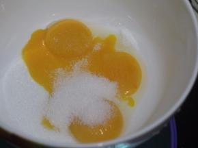 将蛋清和蛋黄分离后，在蛋黄盆子里加入18克细砂糖