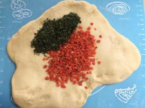 将面团擀成片，把胡萝卜碎和海苔碎撒在上面