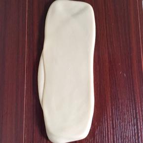 静止好的面团继续用擀面棍擀成长条状