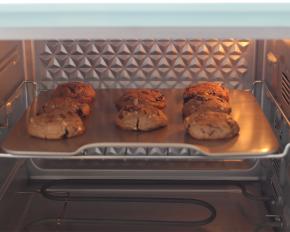 送入预热好的烤箱， 中层烘烤180度15分钟。在烘烤过程中，面团会渐渐摊成大饼。烤到曲奇边缘上色就可以出炉了。