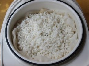 用蒸隔布垫在电饭锅蒸隔篮上，倒入糯米，电饭锅放适量水;PS：用竹蒸笼最好，有竹子清香