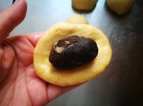 包入豆沙馅，不要太多，我每个放了15克左右，太多了面包烤时会裂开，包成椭圆形