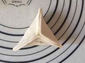 捏成糖三角，捏的时候捏口向下一点，上面就会有胖嘟嘟的边缘