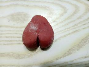 红面团取钢镚那么大一块，做成心型，用尺子由下向上推做成小猫爪子的肉垫形状