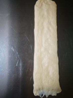 将刚才醒发好的面团排气，擀成长条形，长度有28厘米左右，这个长度比较好，宽度比土司盒的宽度稍窄些就可以