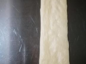 将刚才醒发好的面团排气，擀成长条形，长度有28厘米左右，这个长度比较好，宽度比土司盒的宽度稍窄些就可以