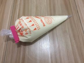 把蛋糕糊装进裱花袋中
(事先准备好裱花袋用一个杯子把袋子装好，
以免倒蛋黄糊时手忙脚乱的)
这时先预热烤炉180度10分钟