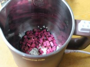 把浸泡的大米、紫薯块放入豆浆机中，加上适量的清水；