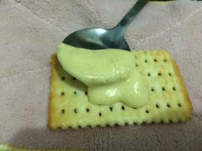 然后把一片咸饼干放平，趁热一小勺上面准备好的内馅，快速的合上另一片咸饼干