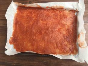 取出一部分倒在烤盘里，铺上薄薄一层。其余的倒进保鲜盒里压平，做山楂糕，搓成球裹上糖就是山楂球