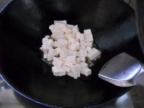 豆腐倒入锅中，颠匀。