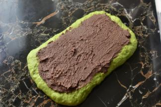 取出排气擀成长方形在表面均匀的抹上豆沙馅（注意边缘不要抹到）