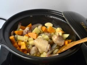 然后加入南瓜、土豆和虾，接着将干辣椒、花椒和少许的豆瓣酱也一起放入小火炒出香味