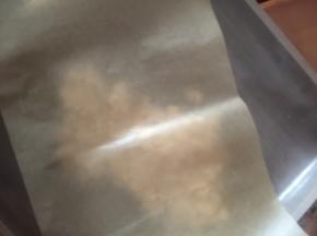 倒入准备好的铺了油布的烤盘里，上面加盖油纸，用擀面杖擀薄