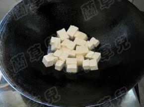 豆腐冲洗一下，切小块。
锅中油热，倒入豆腐块。