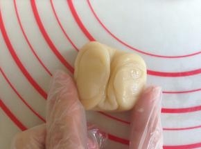 用拇指在中间压一下，对折，压扁