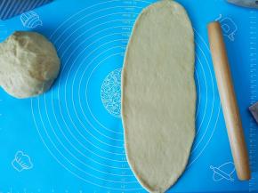 把面团擀成长条状，宽度跟模具宽度差不多