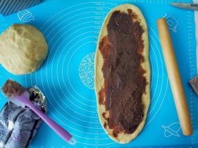 再把豆沙均匀涂抹在长条状，再卷回来