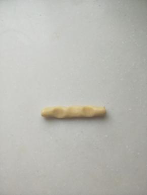，
搓成长条，三个指头按下去，形成3个凹坑。