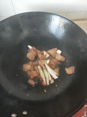 放入葱蒜小米辣继续翻炒