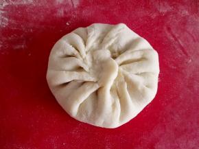 8.	一点点收口，把馅料包好，用手轻轻拍扁，