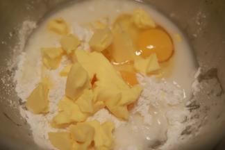 黄油室温软化，预拌粉倒入厨师机桶中，加入清水、鸡蛋