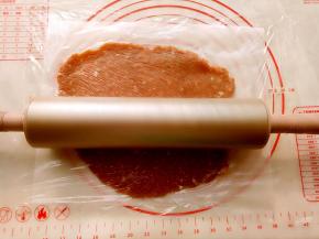 取三分之一肉馅放到油纸上，上面盖上保鲜膜用阳晨金色擀面杖擀成2毫米左右的薄片。