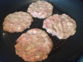 将肉泥取一块在手心里压成圆饼状，放入平底锅