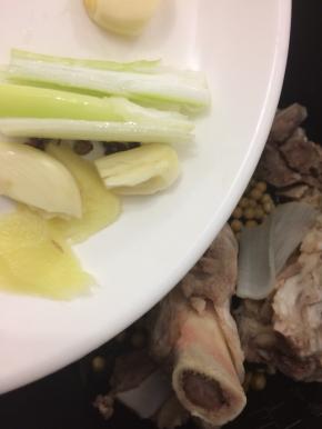 在把蒜、姜、大料、花椒和葱倒入