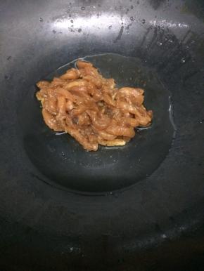 炒锅里加入少许的油烧热后，把腌好的肉丝放入锅中划开