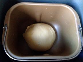 除黄油和葡萄干及核桃仁外所以原料放进面包机搅拌至出厚膜，加入黄油继续揉