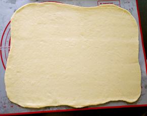 用擀面杖将面团擀成长40厘米，宽30厘米，厚0.3厘米的薄片