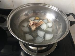炖好的汤底放入火锅盆，加入白萝卜一起煮