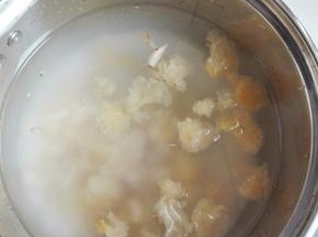 大米淘洗干净放入锅中，银耳摘掉根部硬块，撕成小朵与百合一同放入锅中，放入清水