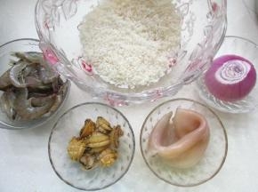 大米洗净，各种材料备用，把鱿鱼切圈，洋葱切丁。