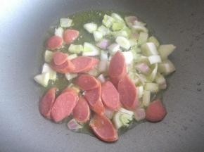 倒入洋葱末和肠仔片煸炒香。