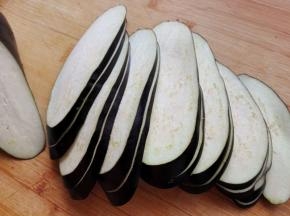 3.	茄子去蒂，洗净，斜着切片，注意，每两片要连在一起，即第一刀不切断，第二刀切断，