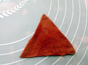 取40克的红色的面团，擀好的面饼切成如上图指示的三角形，如图上中的样子。